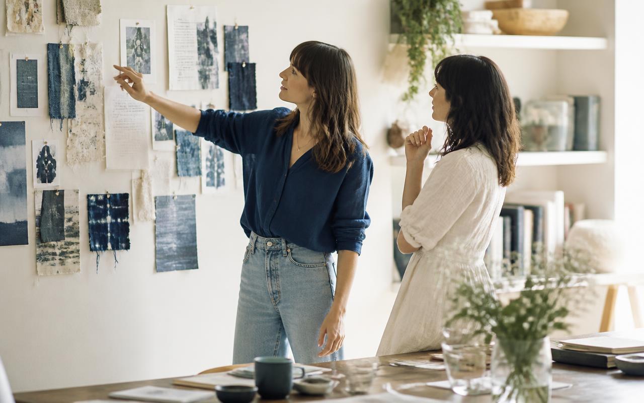 Two women collaborating at a creative studio mood board